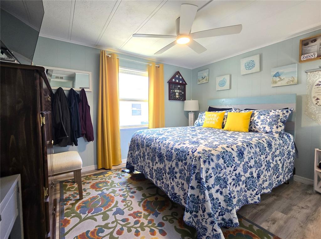 5619 Bayshore Road, Unit 435 Palmetto, FL 34221 - Photo 18 of 56 a bedroom with a bed a dresser and a chandelier