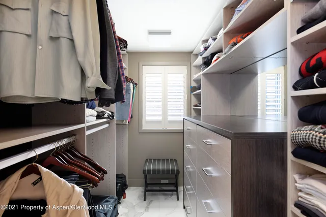 a view of walk in closet with clothes and shoes
