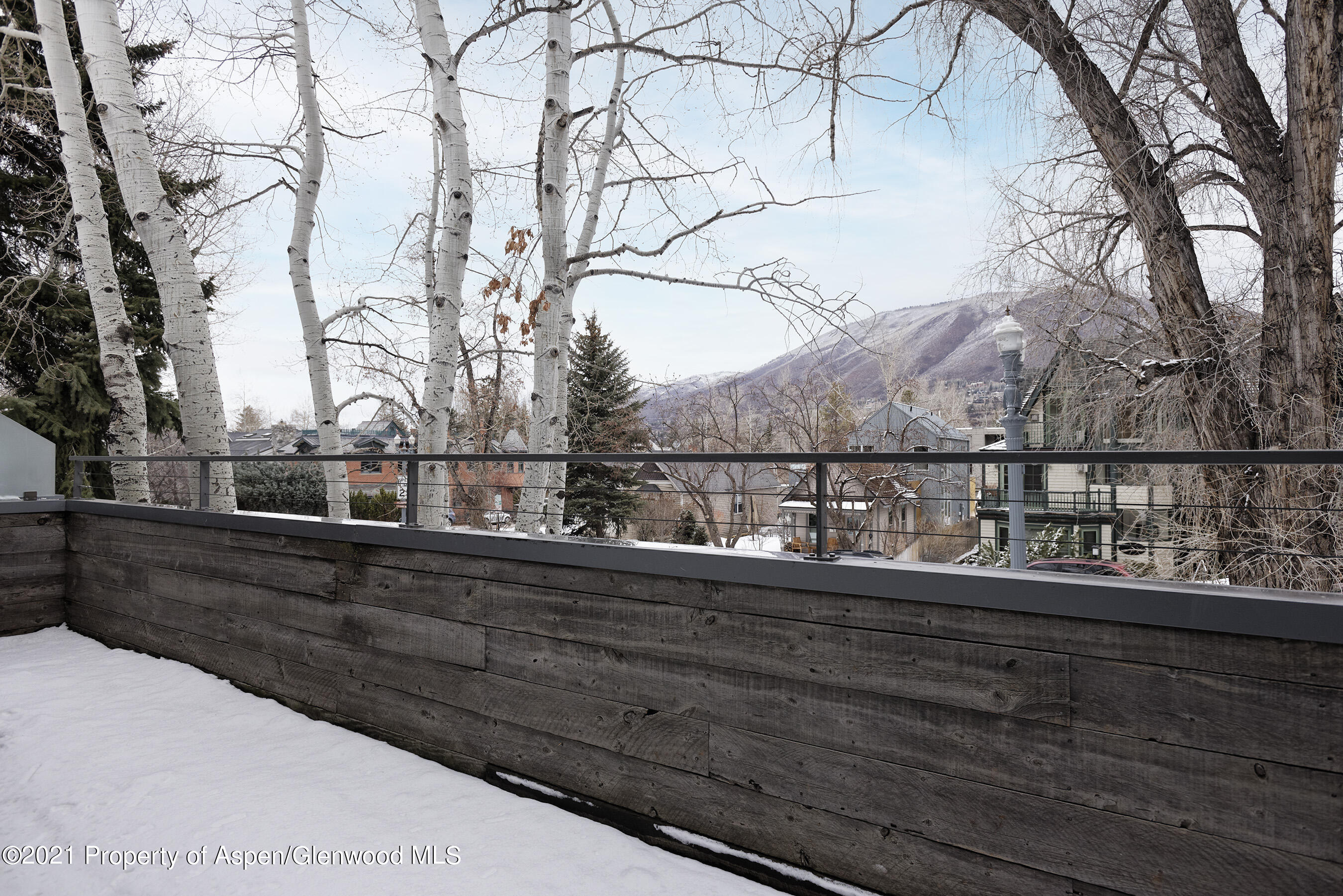 1001 East Cooper Avenue, Unit 2 Aspen, CO 81611 - Photo 17 of 17 a view of a balcony with wooden fence and trees