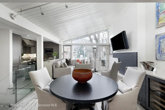 a living room with furniture a flat screen tv and a large window
