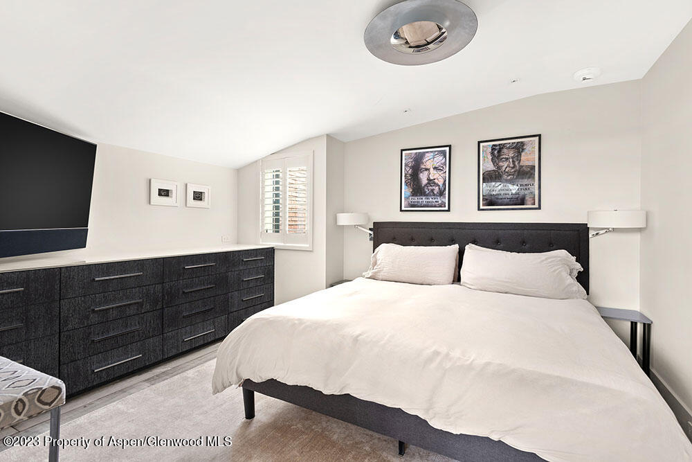 1001 East Cooper Avenue, Unit 2 Aspen, CO 81611 - Photo 7 of 17 a bedroom with a bed and a flat screen tv