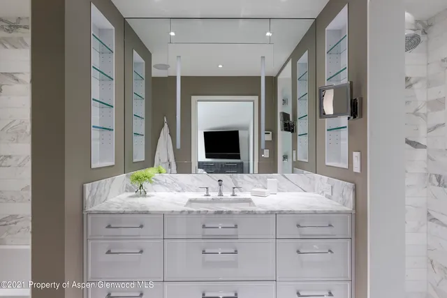 a bathroom with a granite countertop sink vanity mirror and shower