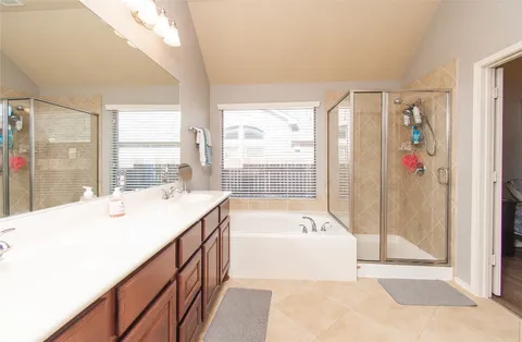 a spacious bathroom with a tub sink and shower
