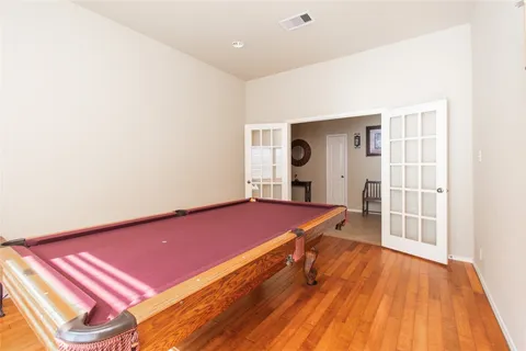a room with wooden floor and pool table