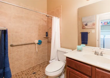 a bathroom with a sink a toilet and shower