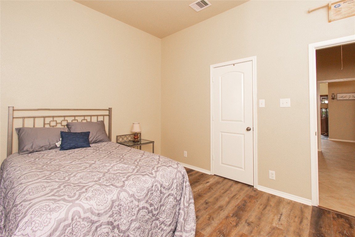 947 Madrone Drive Georgetown, TX 78628 - Photo 26 of 32 a bedroom with a large bed and wooden floor
