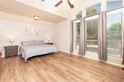a bedroom with a bed and wooden floor