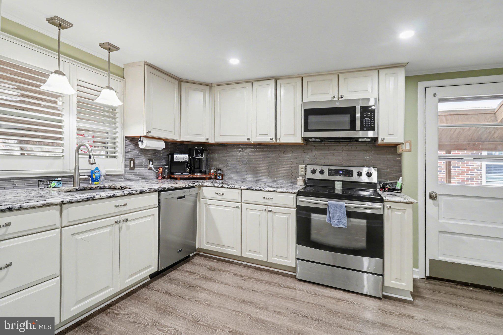 609 North Franklin Street Pottstown, PA 19464 - Photo 13 of 41 a kitchen with stainless steel appliances granite countertop a stove a sink and a microwave