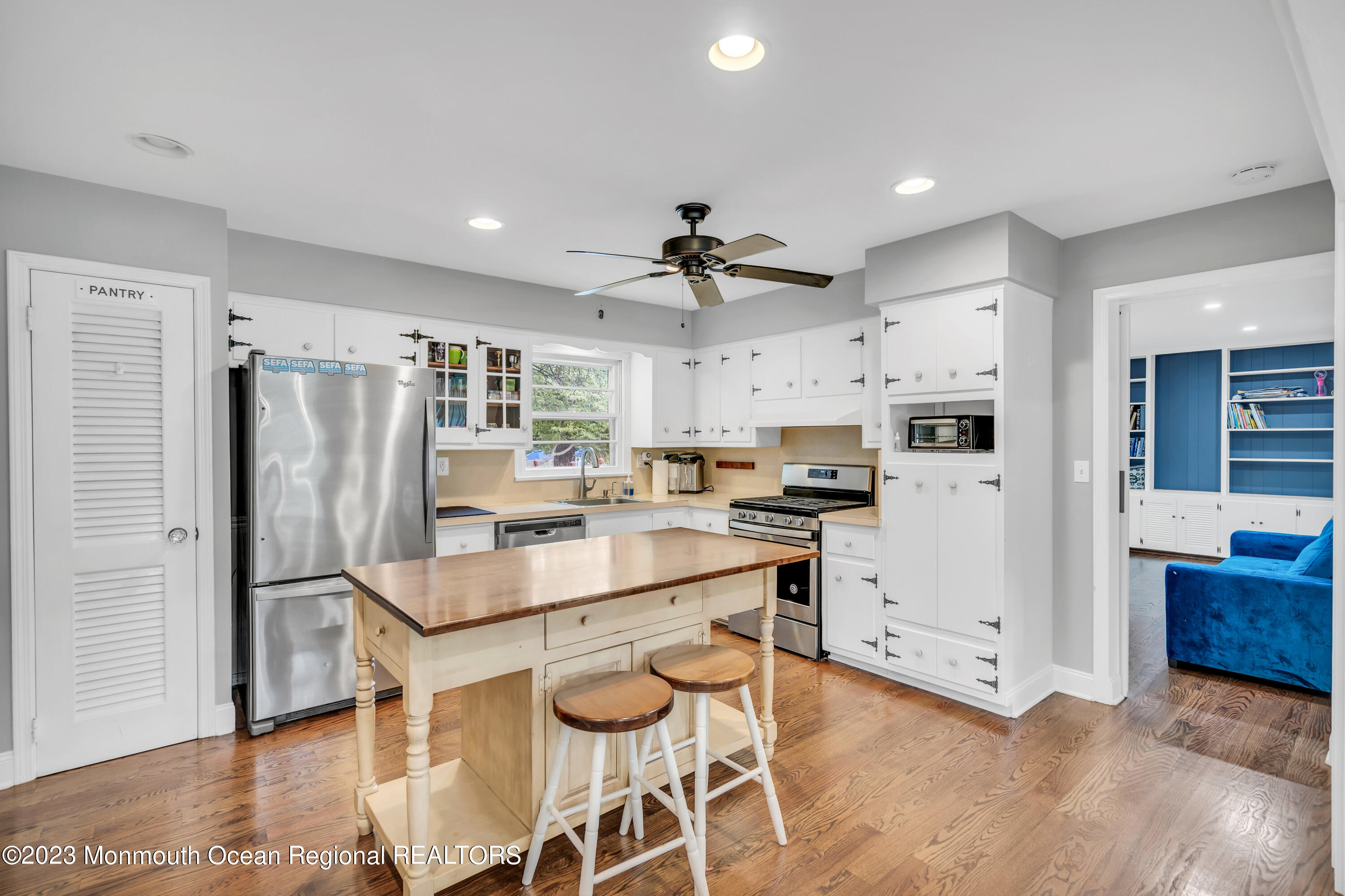 3 Alvord Street Oakhurst, NJ 07755 - Photo 11 of 20 a kitchen with kitchen island a stove a refrigerator and a dining table with wooden floor
