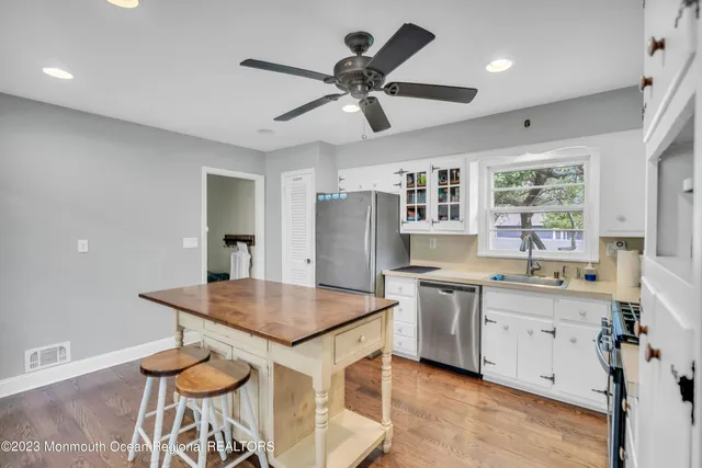 a kitchen with a table chairs sink and cabinets