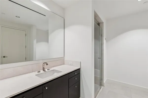 a view of a hallway with wooden floor and a bathroom