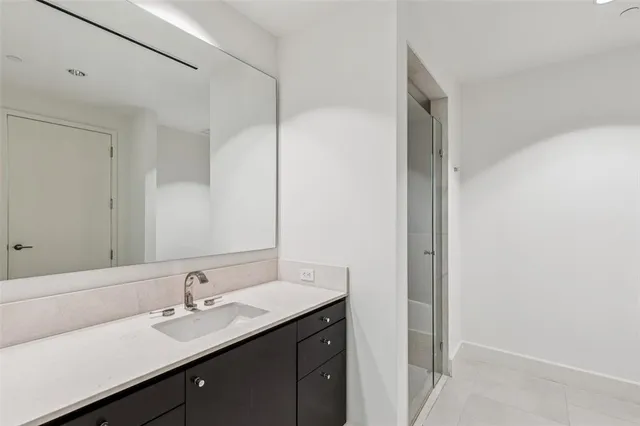 a view of a hallway with wooden floor and a bathroom
