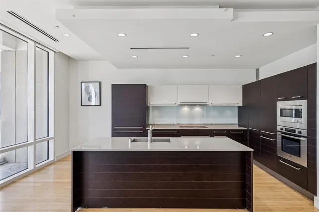 a kitchen with a refrigerator and chairs