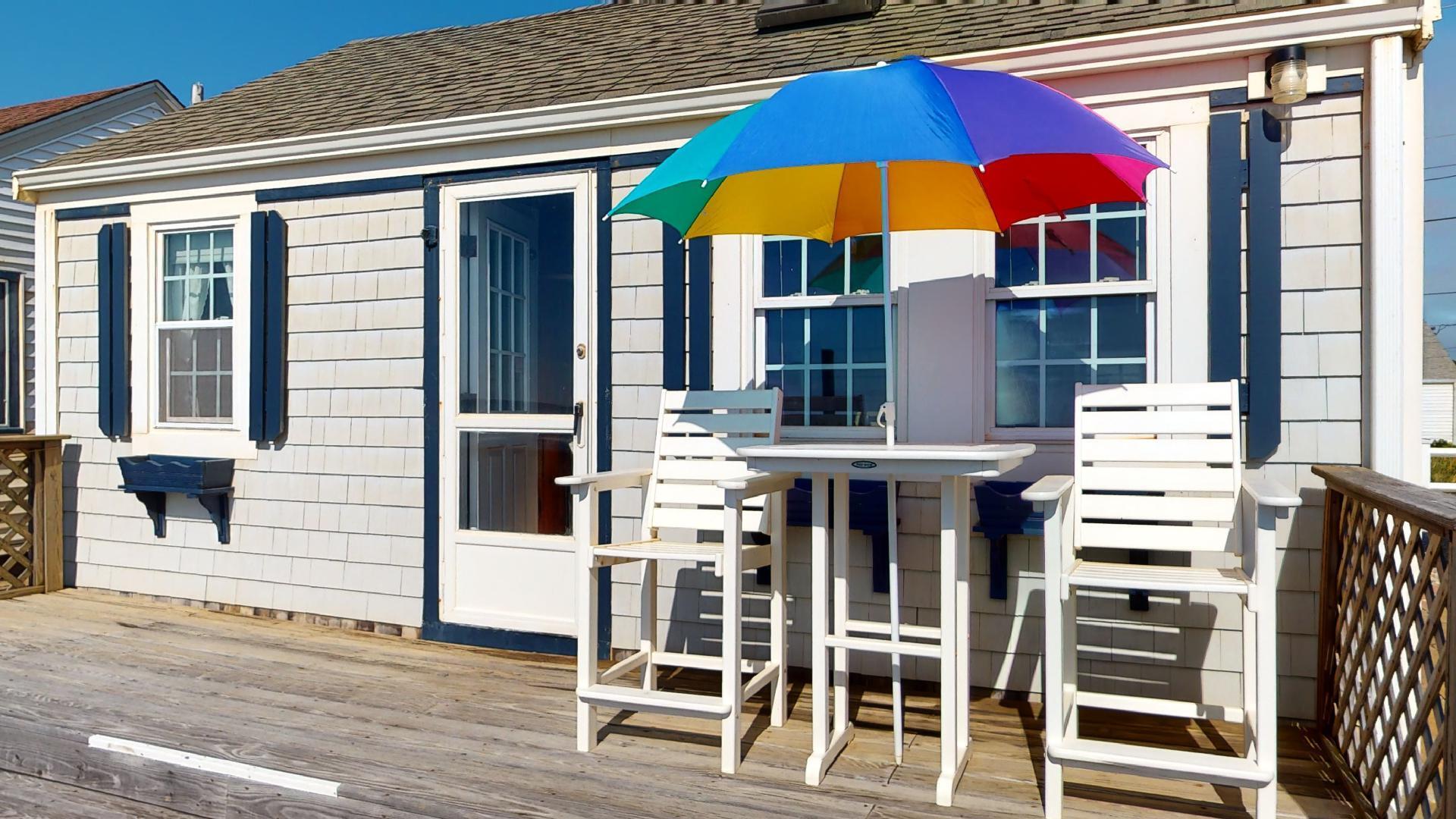 334 Shore Road, Unit 11 Truro, MA 02666 - Photo 22 of 26 a view of a cafe with table and chairs under an umbrella