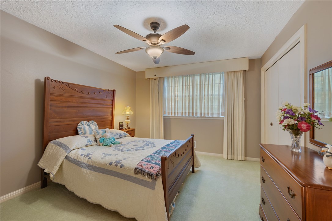 503 Calvert Street Hearne, TX 77859 - Photo 13 of 30 Bedroom featuring light colored carpet, ceiling fan, multiple windows, a textured ceiling, and a closet