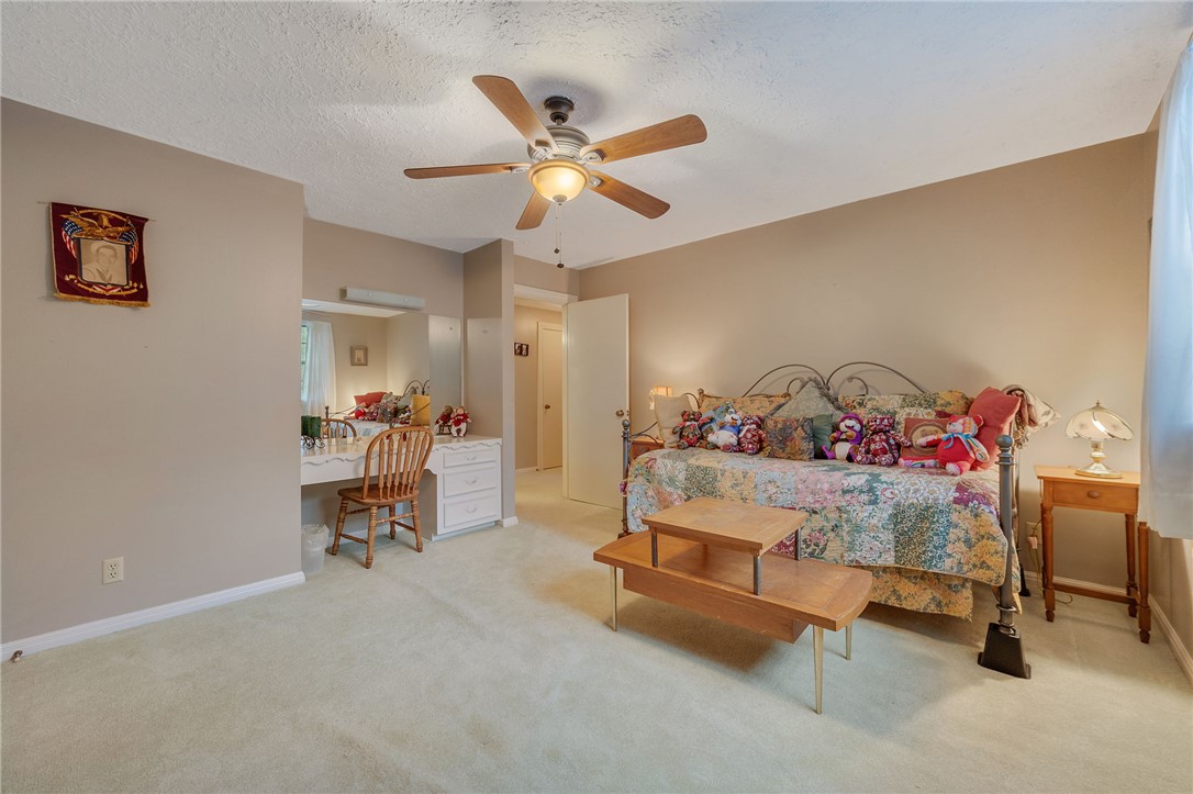 503 Calvert Street Hearne, TX 77859 - Photo 16 of 30 Bedroom featuring light carpet, built in study area, a ceiling fan, and a textured ceiling