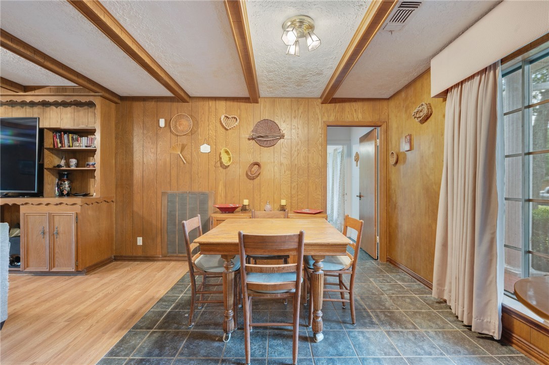 503 Calvert Street Hearne, TX 77859 - Photo 19 of 30 Dining room with wooden walls, beam ceiling, and a textured ceiling