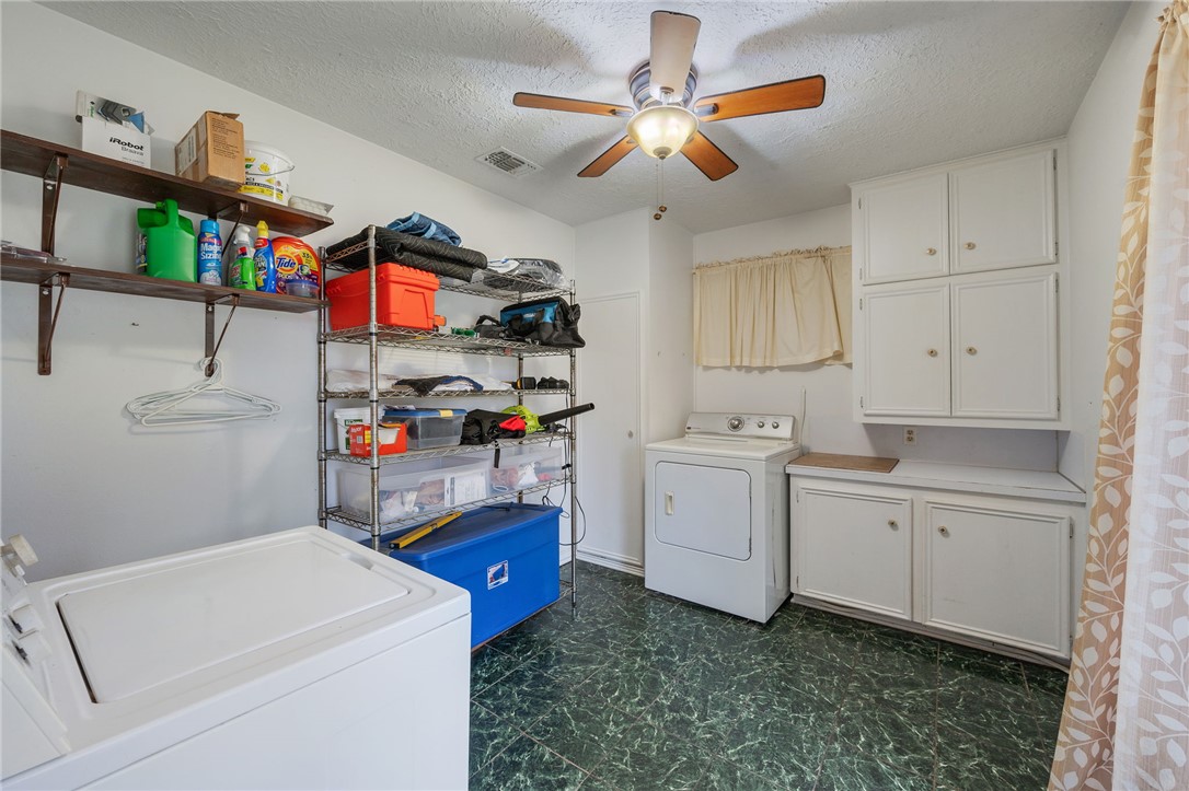 503 Calvert Street Hearne, TX 77859 - Photo 22 of 30 Laundry room featuring cabinet space, a textured ceiling, a ceiling fan, and washer and dryer