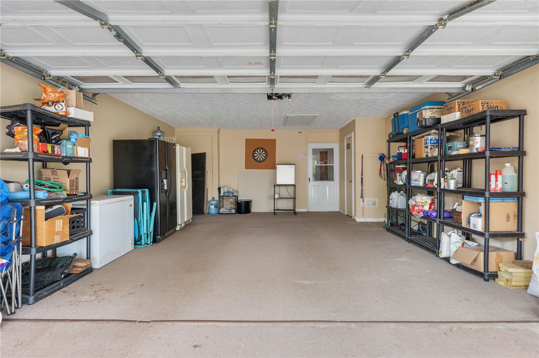 503 Calvert Street Hearne, TX 77859 - Photo 23 of 30 Garage with white fridge and black refrigerator with ice dispenser