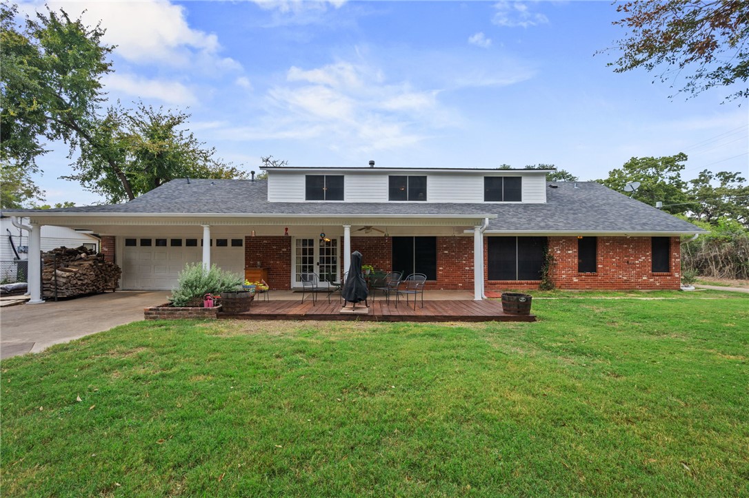 503 Calvert Street Hearne, TX 77859 - Photo 25 of 30 Traditional-style house with a garage, brick siding, concrete driveway, and a front yard