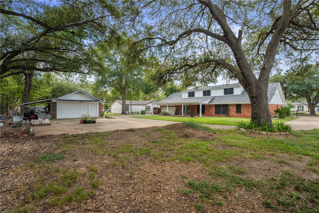 503 Calvert Street Hearne, TX 77859 - Photo 27 of 30 View of front facade with brick siding, a front yard, concrete driveway, and a patio area