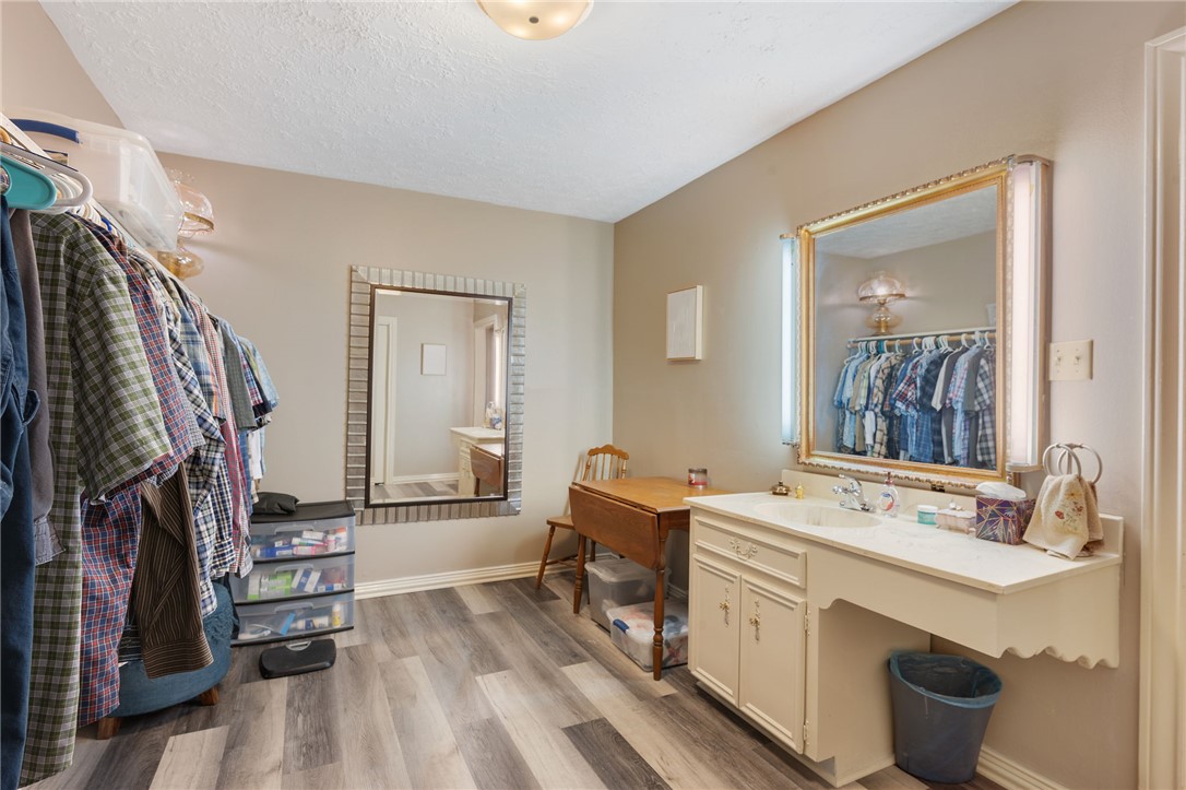 503 Calvert Street Hearne, TX 77859 - Photo 8 of 30 Bathroom featuring light wood-style flooring, vanity, and a textured ceiling