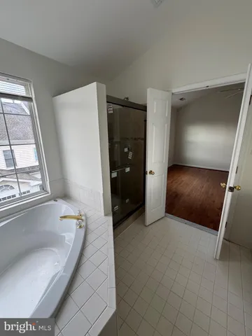 a bathroom with a tub and mirror