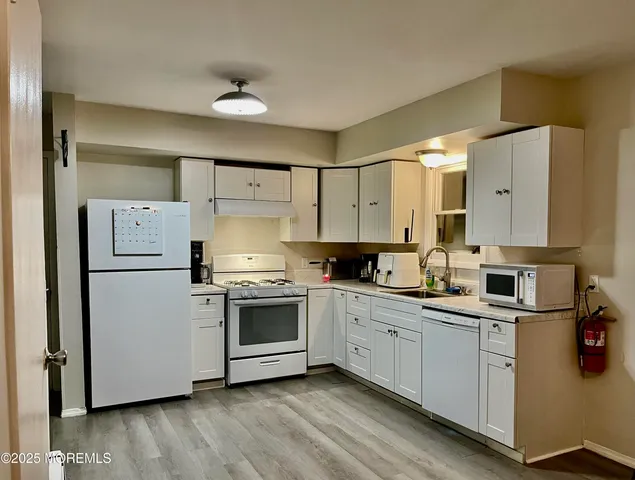 a kitchen with white cabinets and white appliances