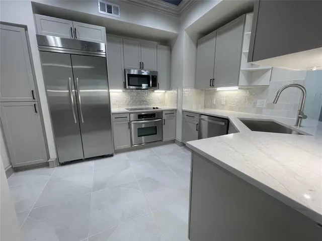 a kitchen with a sink stainless steel appliances and cabinets