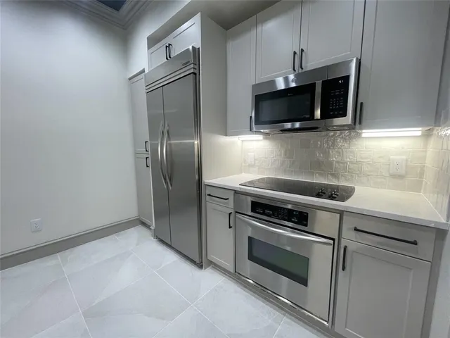 a kitchen with stainless steel appliances granite countertop a sink a stove and a refrigerator