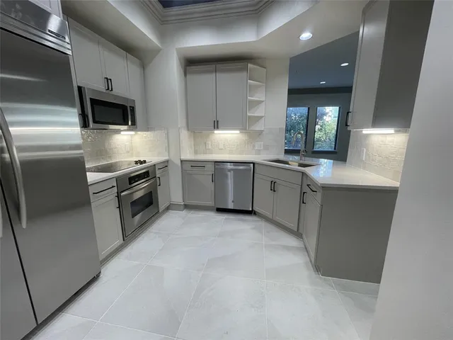 a kitchen with stainless steel appliances a refrigerator sink and stove