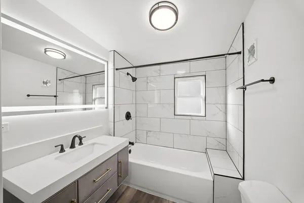 a bathroom with a tub sink a toilet and a shower