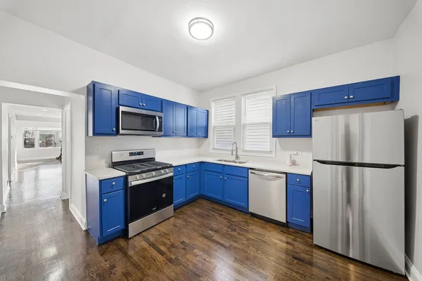 a kitchen with stainless steel appliances granite countertop a refrigerator stove a sink dishwasher and microwave with wooden floor