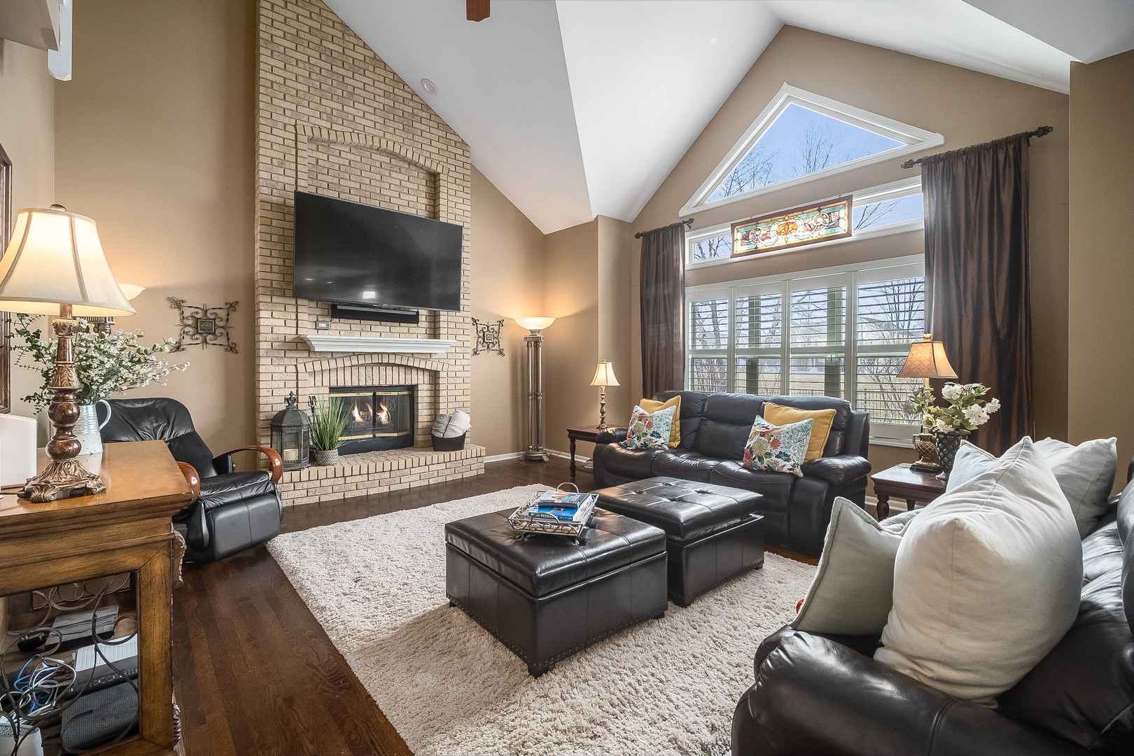 13130 Sunderlin Road Plainfield, IL 60585 - Photo 3 of 33 a living room with furniture a flat screen tv and a fireplace