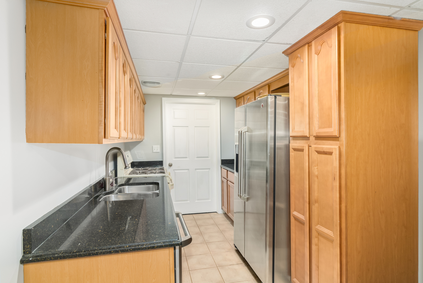13130 Sunderlin Road Plainfield, IL 60585 - Photo 27 of 33 a kitchen with a sink a refrigerator and cabinets
