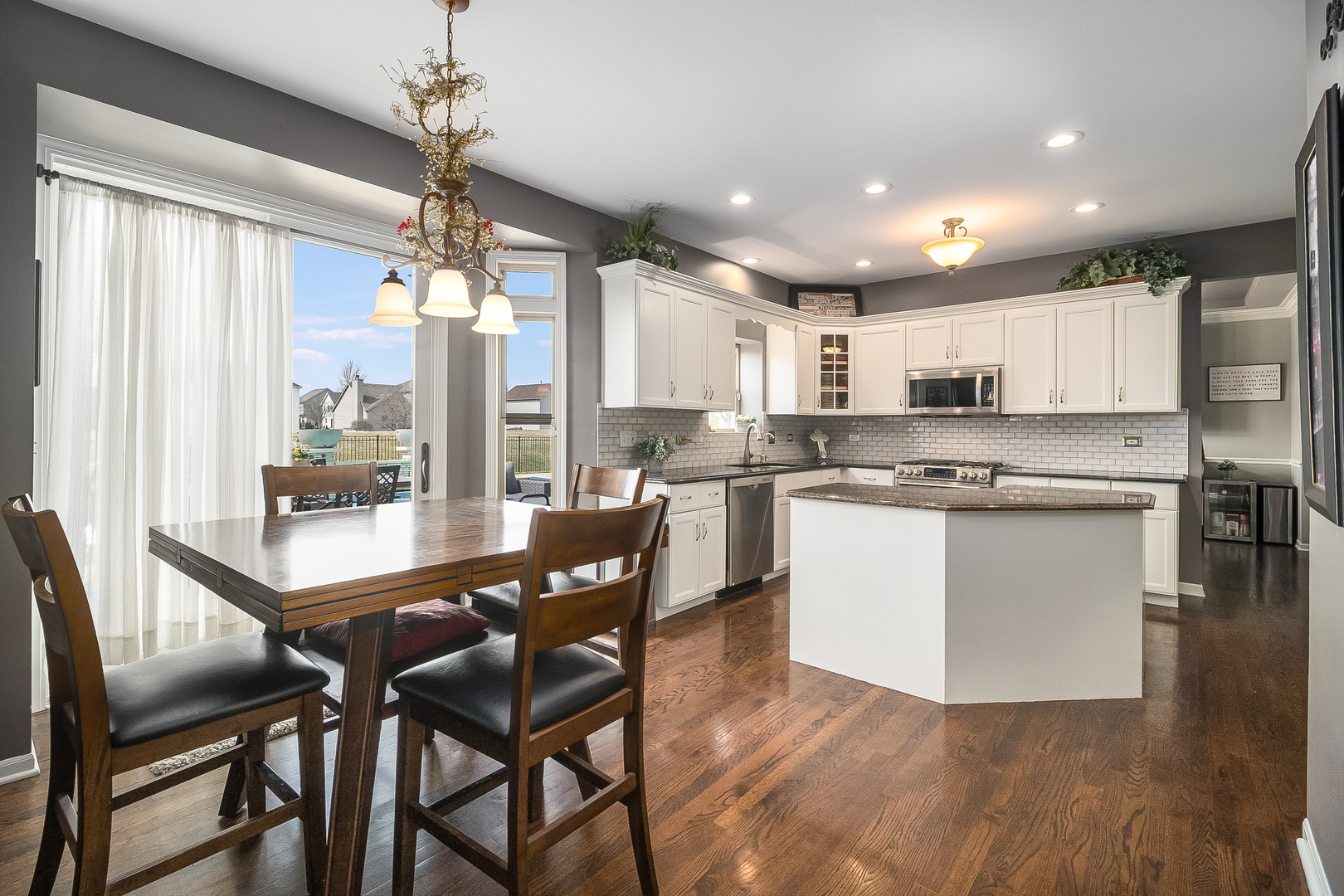 13130 Sunderlin Road Plainfield, IL 60585 - Photo 7 of 33 a kitchen with stainless steel appliances kitchen island granite countertop a table chairs and a refrigerator