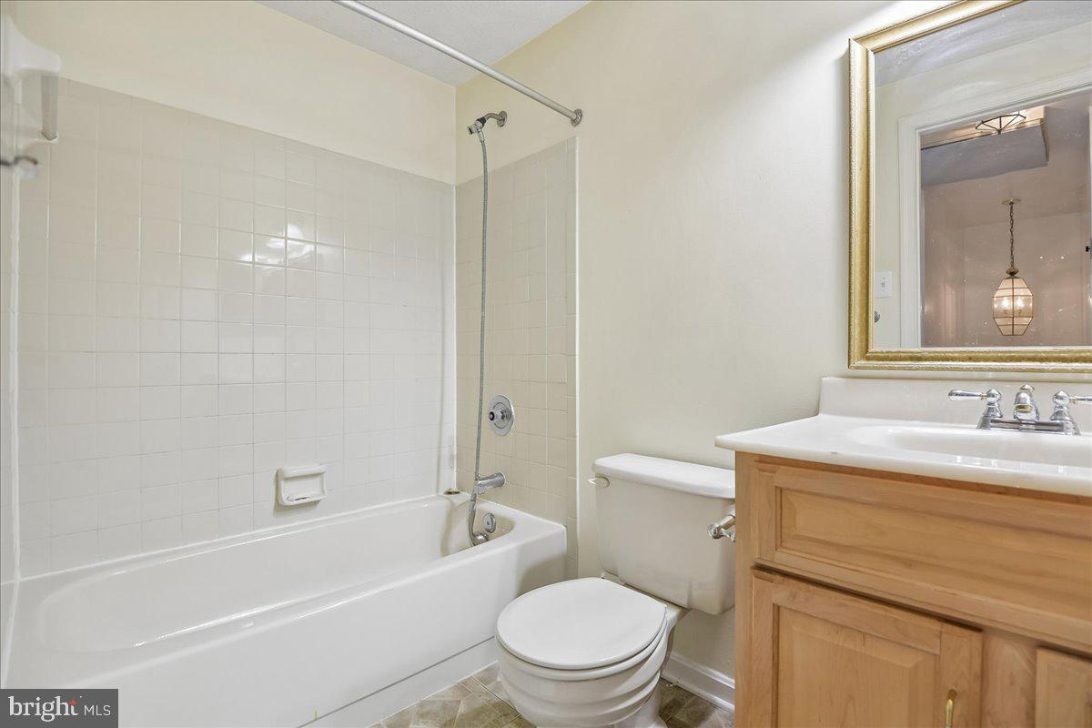 6413 White Peach Place Columbia, MD 21045 - Photo 12 of 31 a bathroom with a granite countertop toilet a sink and a bathtub