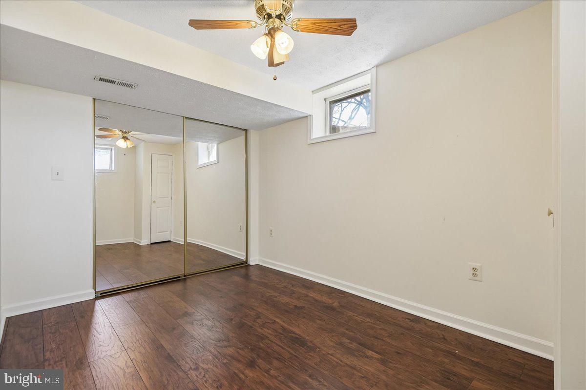 6413 White Peach Place Columbia, MD 21045 - Photo 14 of 31 an empty room with wooden floor fan and windows