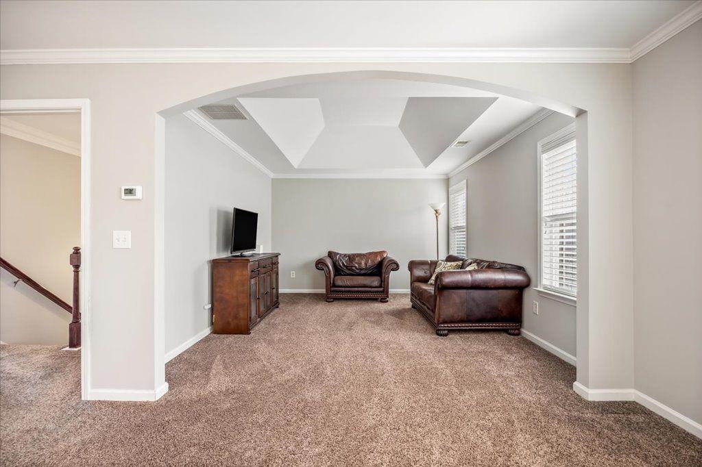 4965 Cheltenham Place Cumming, GA 30041 - Photo 17 of 47 a living room with furniture and a flat screen tv