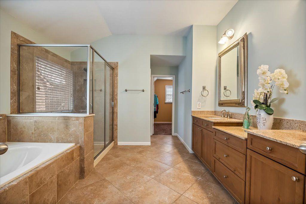 4965 Cheltenham Place Cumming, GA 30041 - Photo 19 of 47 a spacious bathroom with a granite countertop sink a mirror and a bathtub