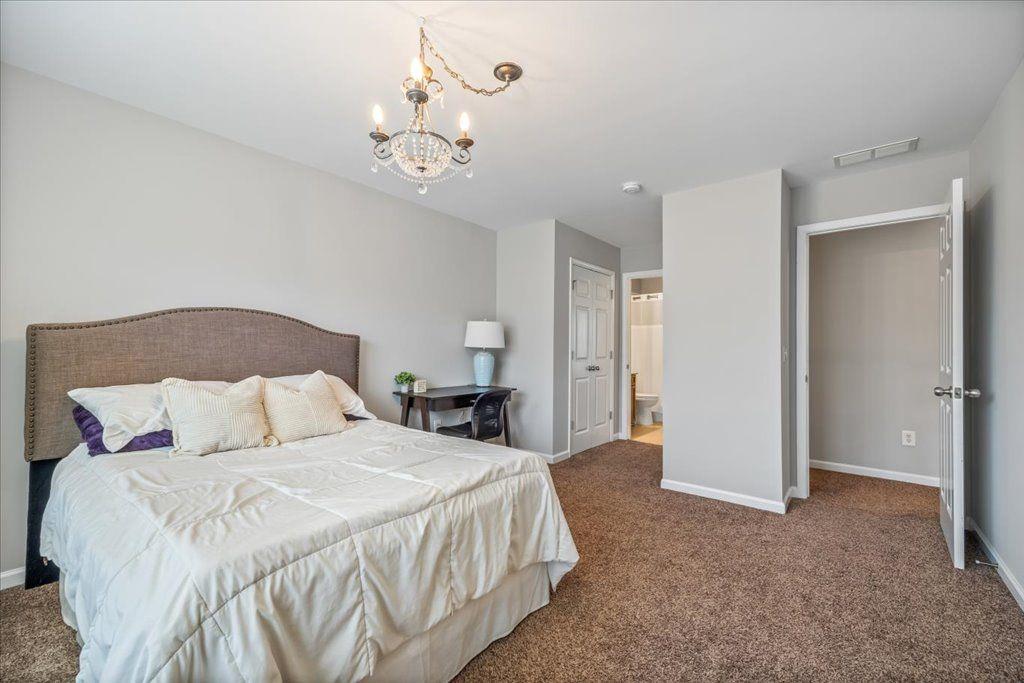 4965 Cheltenham Place Cumming, GA 30041 - Photo 30 of 47 a bedroom with a bed and a chandelier