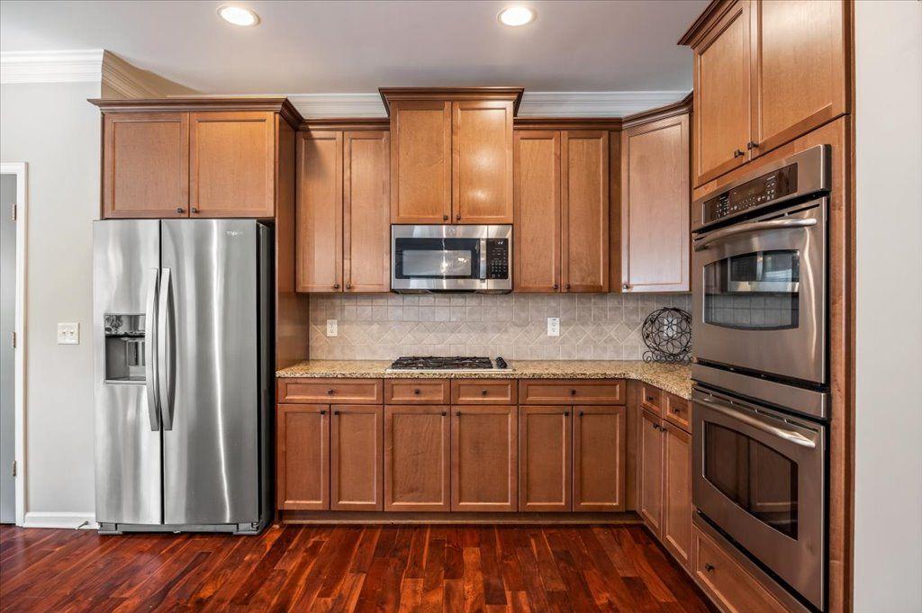 4965 Cheltenham Place Cumming, GA 30041 - Photo 6 of 47 a kitchen with stainless steel appliances a refrigerator stove and sink