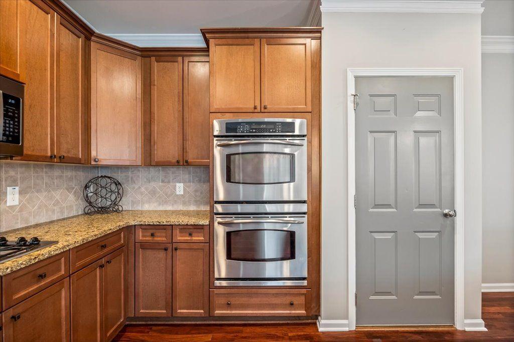 4965 Cheltenham Place Cumming, GA 30041 - Photo 7 of 47 a kitchen with granite countertop a refrigerator and cabinets