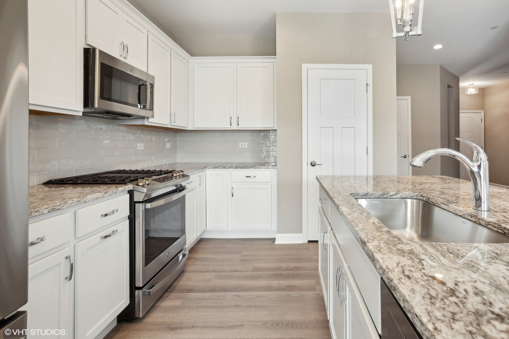253 Masters Drive Addison, IL 60101 - Photo 6 of 17 a kitchen with granite countertop a sink dishwasher microwave stove and cabinets with wooden floor