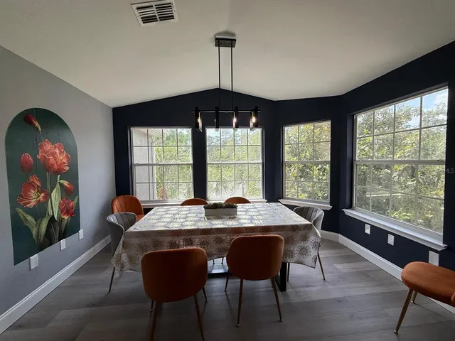 a dining room with furniture a chandelier and wooden floor