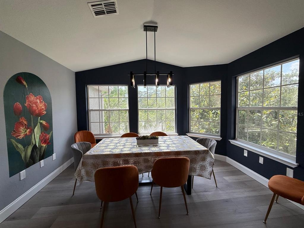 3391 South Kirkman Road, Unit 1236 Orlando, FL 32811 - Photo 17 of 30 a dining room with furniture a chandelier and wooden floor