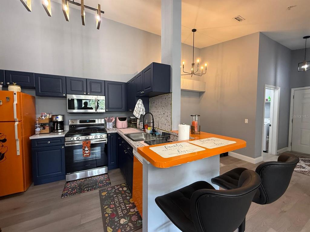 3391 South Kirkman Road, Unit 1236 Orlando, FL 32811 - Photo 2 of 30 a kitchen with stainless steel appliances granite countertop a sink refrigerator stove and microwave