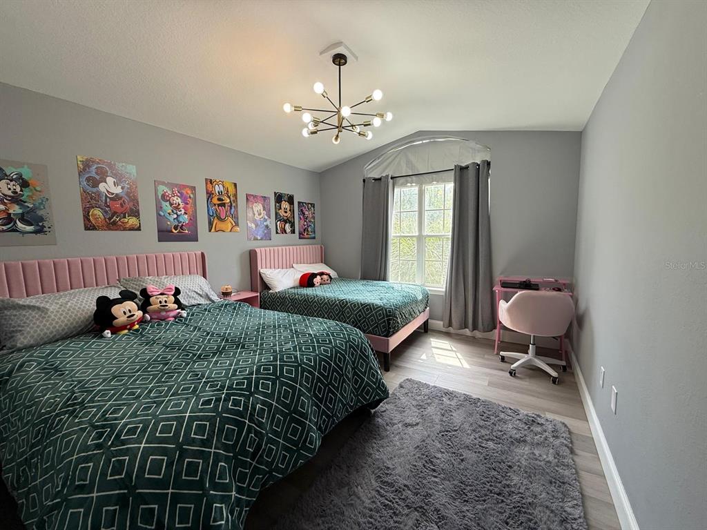 3391 South Kirkman Road, Unit 1236 Orlando, FL 32811 - Photo 23 of 30 a bedroom with a bed and a chandelier