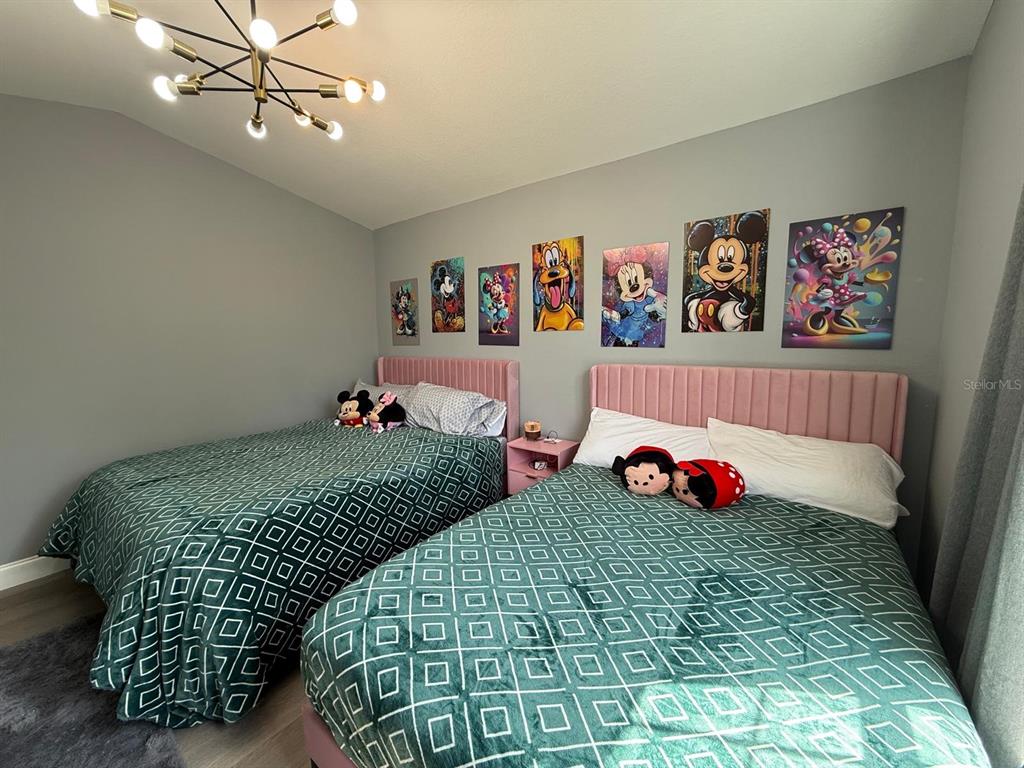 3391 South Kirkman Road, Unit 1236 Orlando, FL 32811 - Photo 24 of 30 a bedroom with two beds and painting on the wall