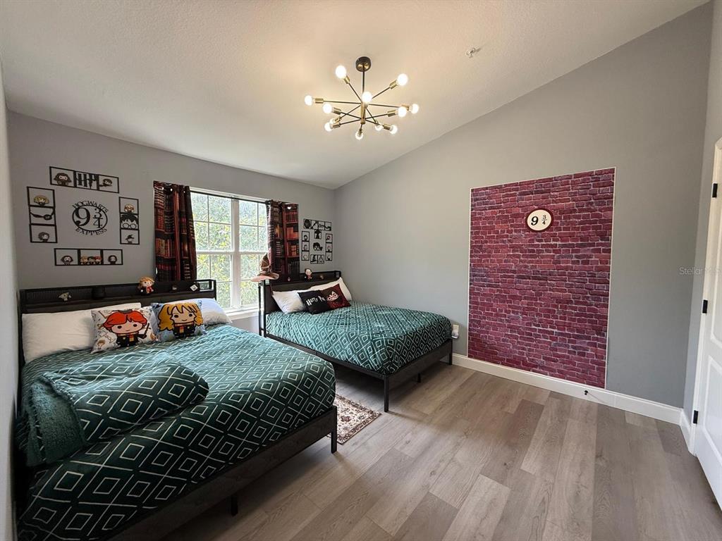 3391 South Kirkman Road, Unit 1236 Orlando, FL 32811 - Photo 26 of 30 a bedroom with a large bed and a chandelier